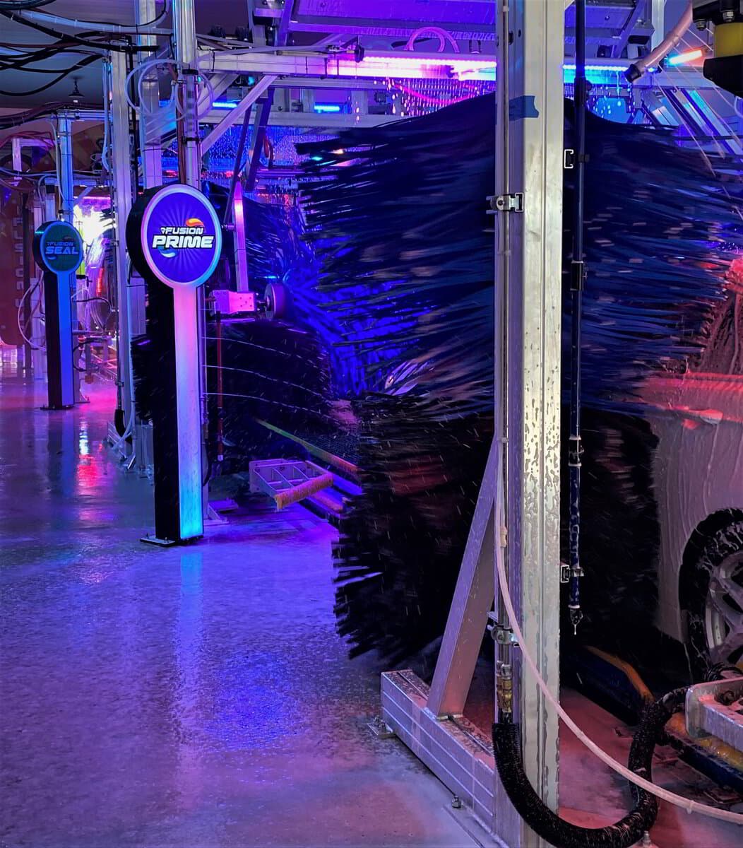 Neon-lit brushes beside the Fusion Prime marker in the Aqua Blue Alpharetta tunnel